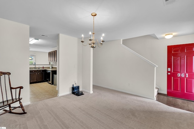 carpeted foyer featuring sink and a notable chandelier