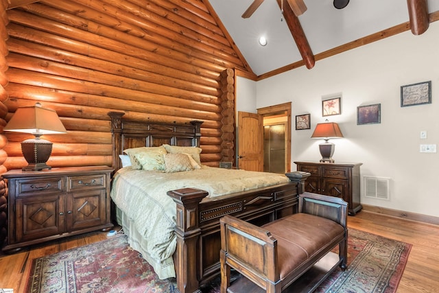 bedroom featuring ceiling fan, light hardwood / wood-style flooring, rustic walls, and high vaulted ceiling