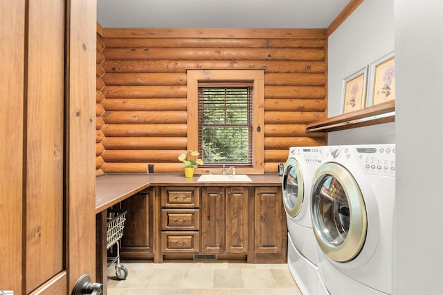 laundry room featuring washing machine and dryer, log walls, sink, and cabinets