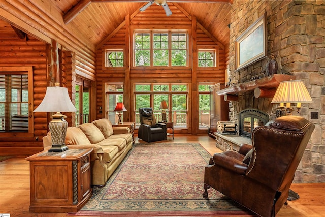 living room featuring high vaulted ceiling, ceiling fan, hardwood / wood-style flooring, and a fireplace