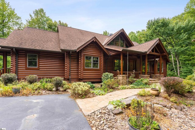 log cabin featuring covered porch