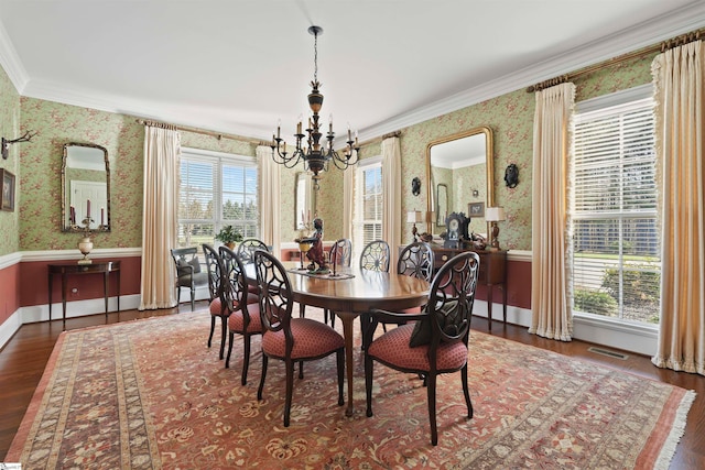 dining area with dark hardwood / wood-style floors, a chandelier, and crown molding