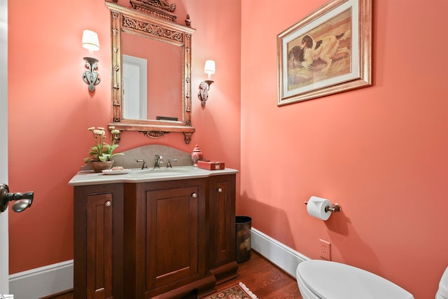 bathroom featuring vanity, toilet, and hardwood / wood-style flooring