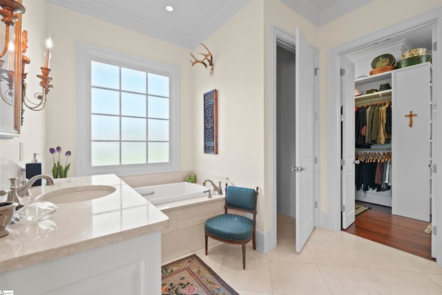 bathroom with ornamental molding, vanity, tile patterned floors, and a relaxing tiled tub