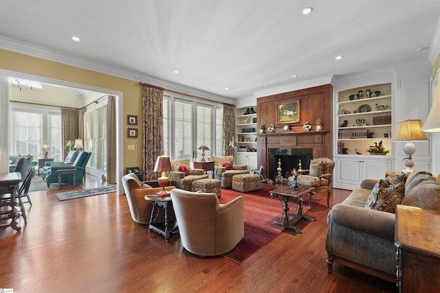 living room with wood-type flooring, ornamental molding, and a healthy amount of sunlight