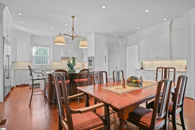 dining area with hardwood / wood-style flooring and crown molding