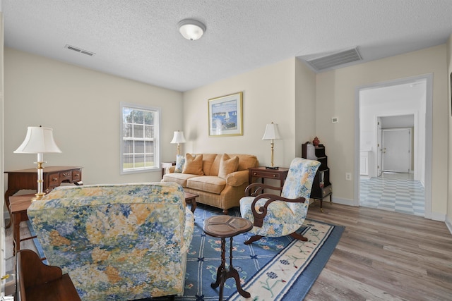 living room featuring a textured ceiling and hardwood / wood-style floors