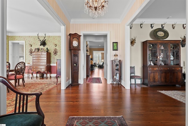 entryway featuring crown molding, dark wood-type flooring, and a chandelier