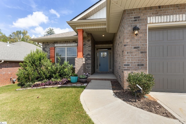 entrance to property featuring a lawn and a garage