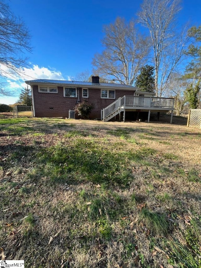 back of house featuring a deck, cooling unit, and a lawn