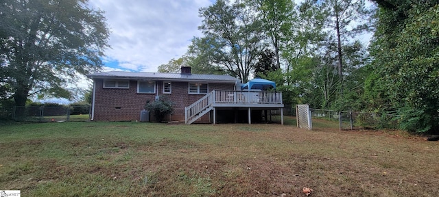 rear view of house with a deck, a yard, and central AC unit