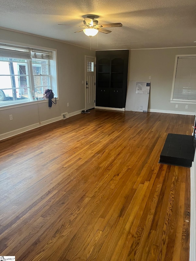 unfurnished living room featuring ceiling fan, hardwood / wood-style flooring, and a textured ceiling