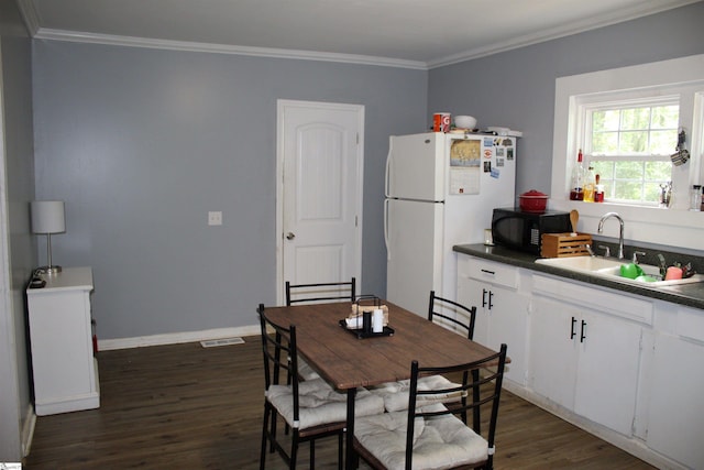 dining room featuring ornamental molding, dark hardwood / wood-style floors, and sink