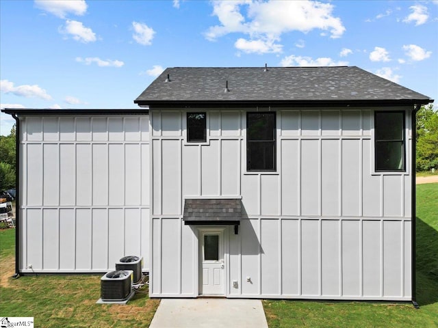 back of property featuring a lawn and central AC unit