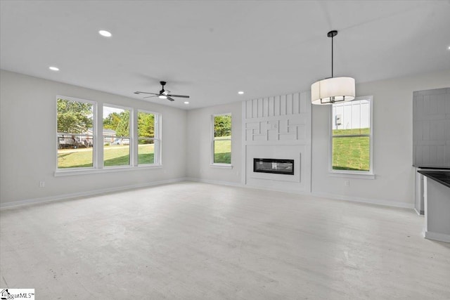 unfurnished living room with ceiling fan