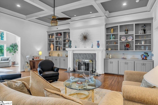 living room featuring ceiling fan, dark hardwood / wood-style floors, beam ceiling, and coffered ceiling