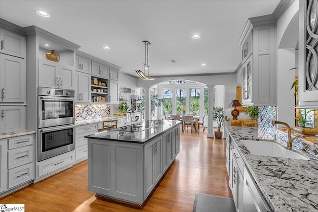 kitchen featuring appliances with stainless steel finishes, decorative columns, sink, and gray cabinetry