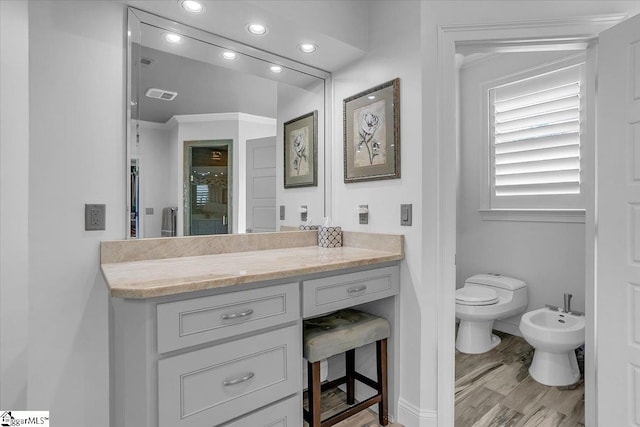 bathroom with vanity, toilet, an enclosed shower, a bidet, and hardwood / wood-style floors