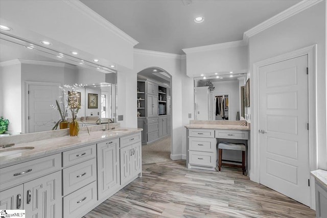 bathroom with hardwood / wood-style flooring, vanity, and crown molding