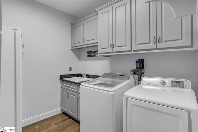 laundry area with cabinets, sink, dark wood-type flooring, and washer and dryer