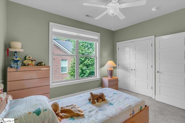 bedroom with ceiling fan, light colored carpet, and a closet