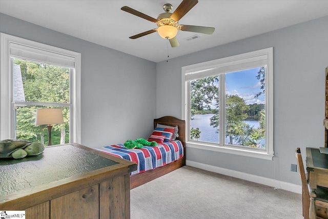 bedroom featuring multiple windows, ceiling fan, and light colored carpet