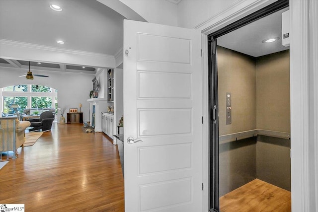 hall with crown molding, hardwood / wood-style floors, and elevator