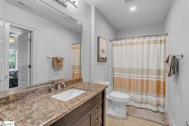 bathroom with ceiling fan, vanity, toilet, a shower with curtain, and tile patterned flooring