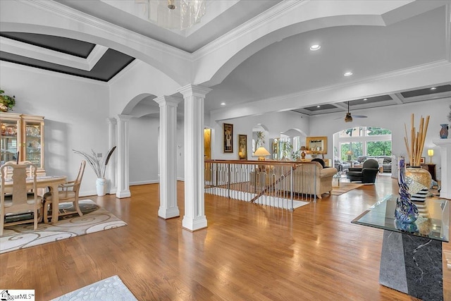 foyer entrance with light wood-type flooring, crown molding, decorative columns, and ceiling fan