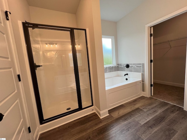 bathroom featuring shower with separate bathtub and wood-type flooring