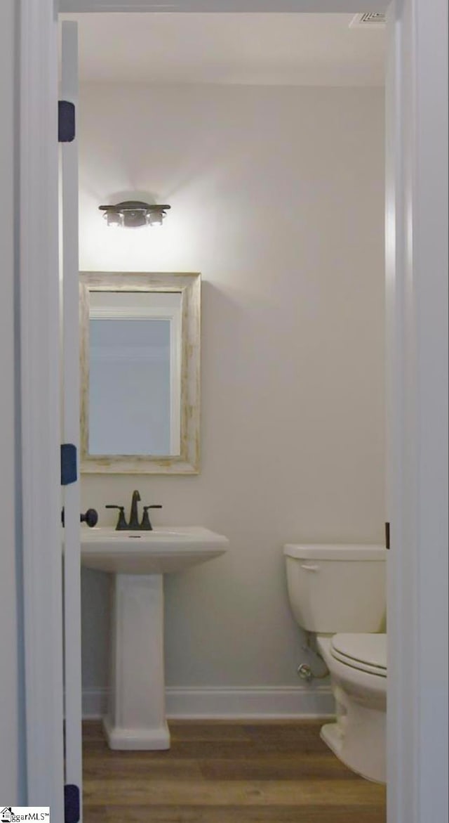 bathroom featuring hardwood / wood-style floors and toilet