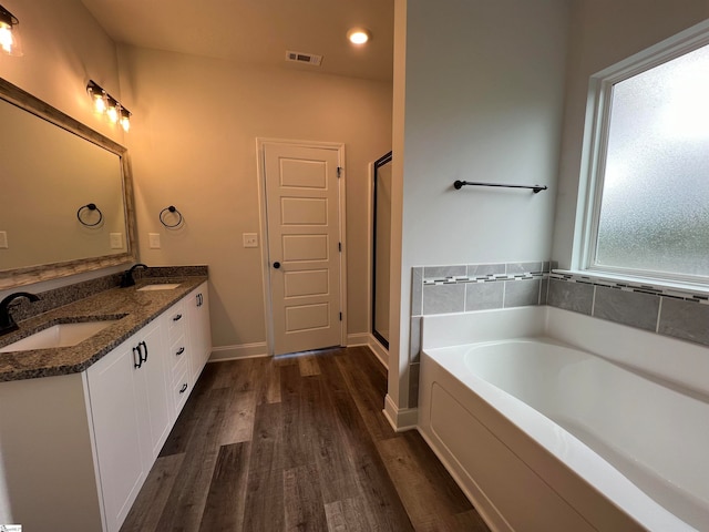 bathroom with shower with separate bathtub, wood-type flooring, and vanity