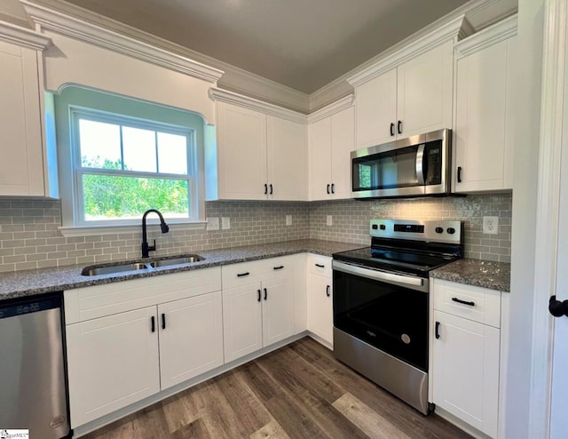 kitchen featuring appliances with stainless steel finishes, tasteful backsplash, white cabinets, dark hardwood / wood-style floors, and sink