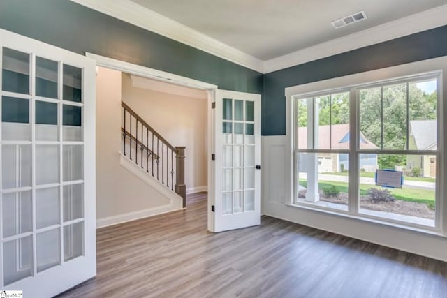 interior space featuring crown molding, hardwood / wood-style floors, and french doors