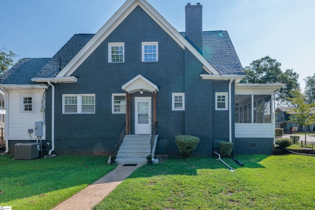 view of front of house featuring a sunroom, central AC, and a front yard