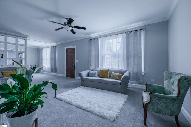 living room featuring carpet, ornamental molding, and ceiling fan