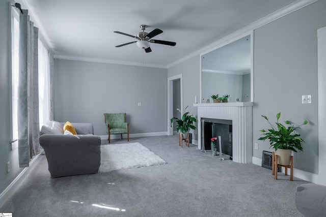 living room featuring carpet, ornamental molding, and ceiling fan