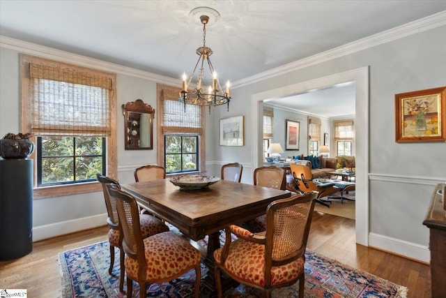 dining area featuring a chandelier, hardwood / wood-style floors, and crown molding