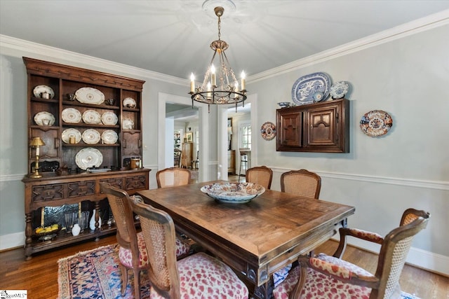 dining room with ornamental molding, a chandelier, and hardwood / wood-style floors