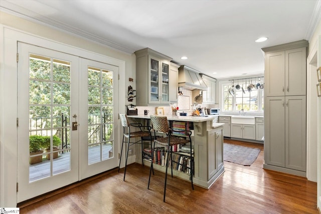 kitchen featuring gray cabinetry, a kitchen bar, plenty of natural light, and kitchen peninsula