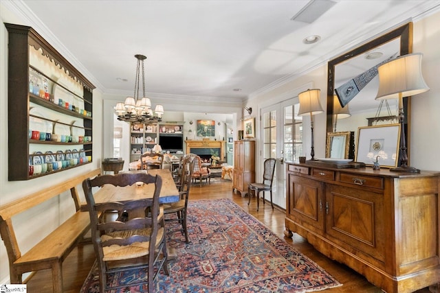 dining room with ornamental molding, dark wood-type flooring, french doors, and a notable chandelier