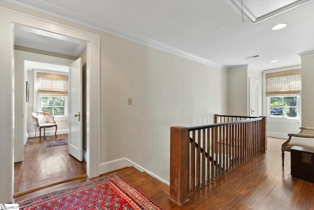 corridor with crown molding, dark hardwood / wood-style floors, and plenty of natural light