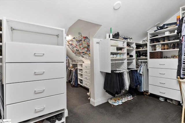 spacious closet with dark carpet and lofted ceiling