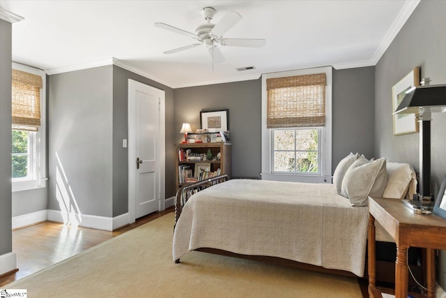 bedroom featuring ornamental molding, light hardwood / wood-style floors, and ceiling fan