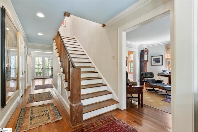 stairs featuring french doors, ornamental molding, and hardwood / wood-style floors