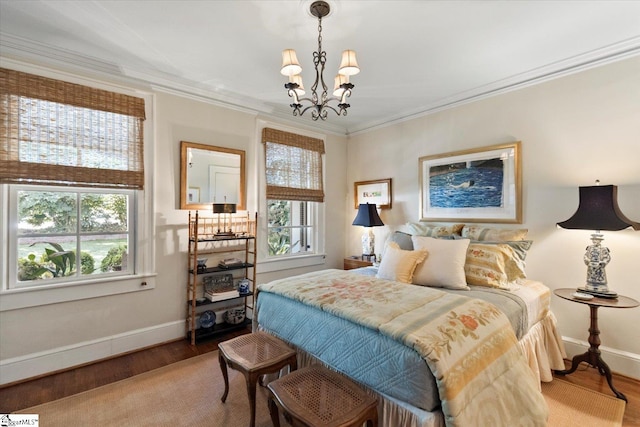 bedroom featuring multiple windows, ornamental molding, a notable chandelier, and hardwood / wood-style flooring