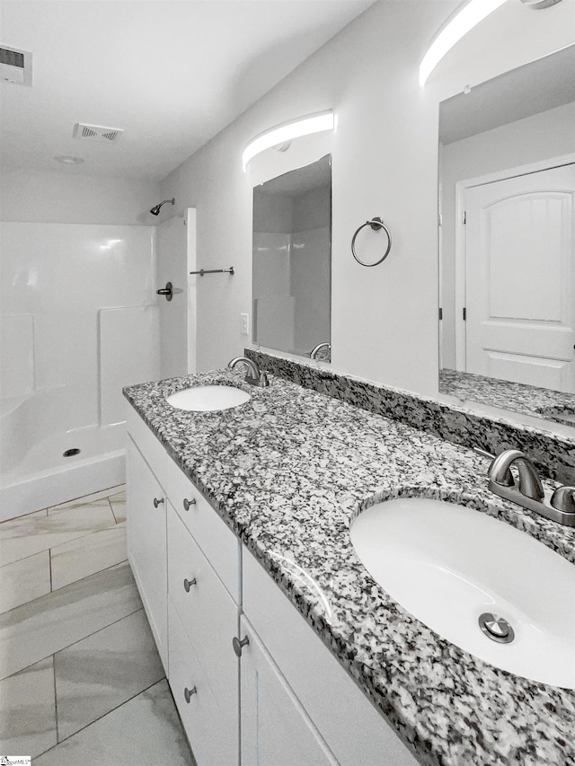 bathroom featuring a shower, vanity, and tile patterned floors