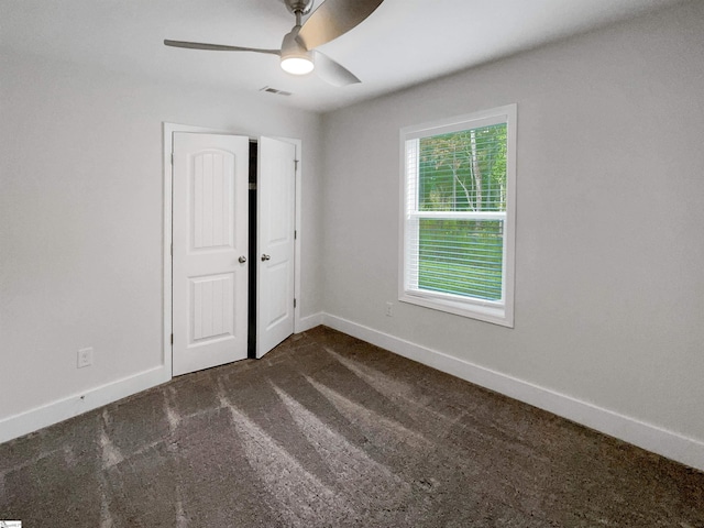 carpeted spare room featuring ceiling fan