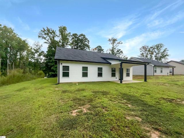 rear view of house featuring a yard and a patio area