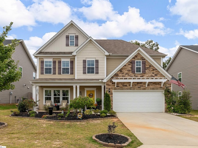 craftsman inspired home with covered porch, a front yard, and a garage